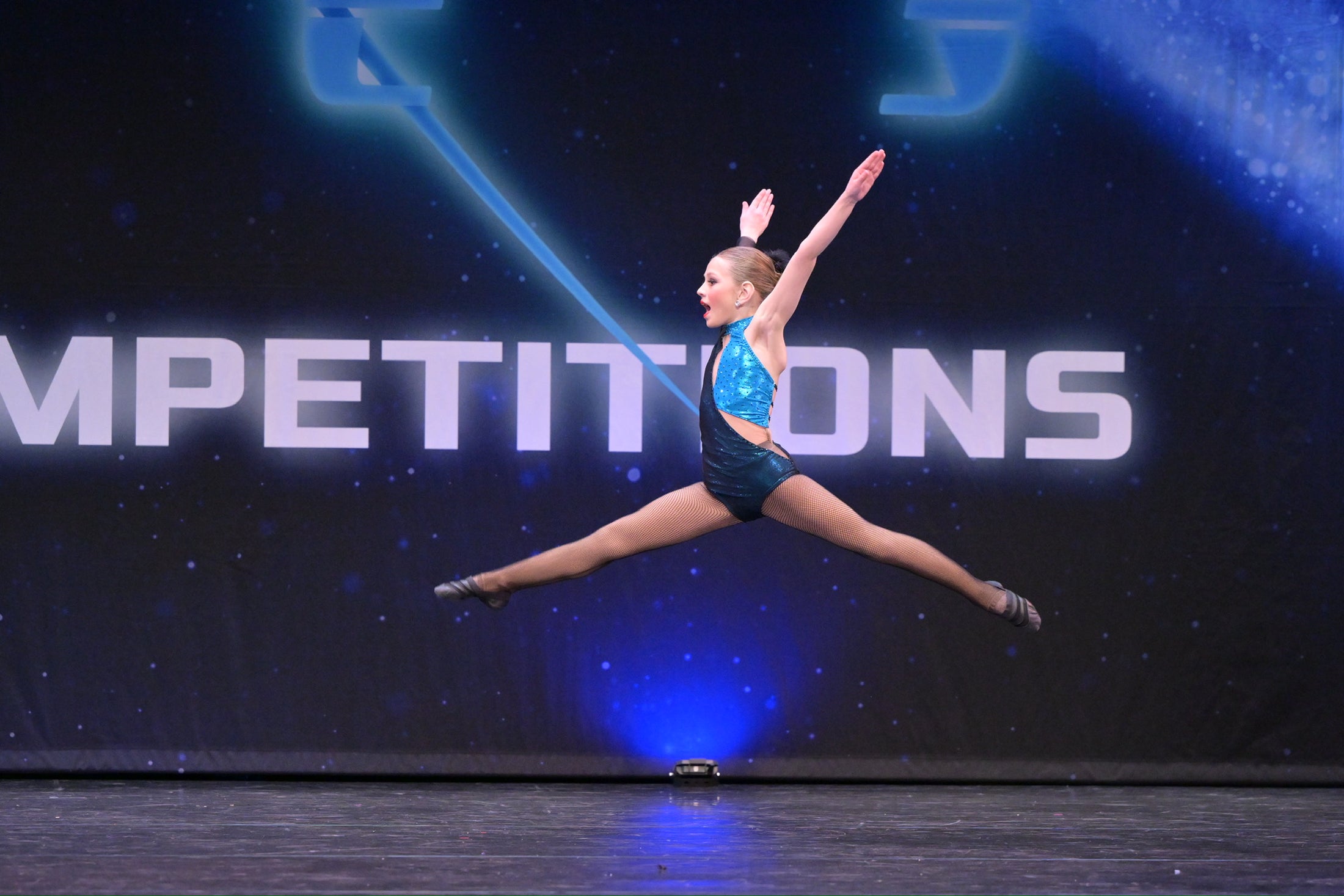 Mia performing a split leap on a competition stage
