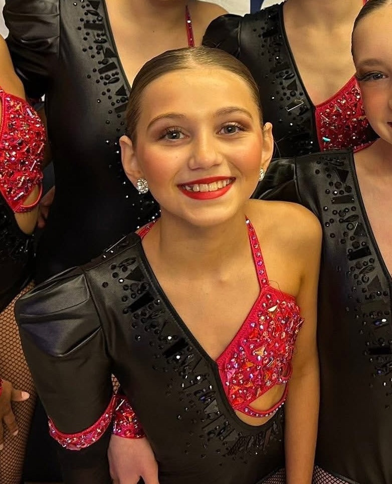 Mia smiling with her competition team