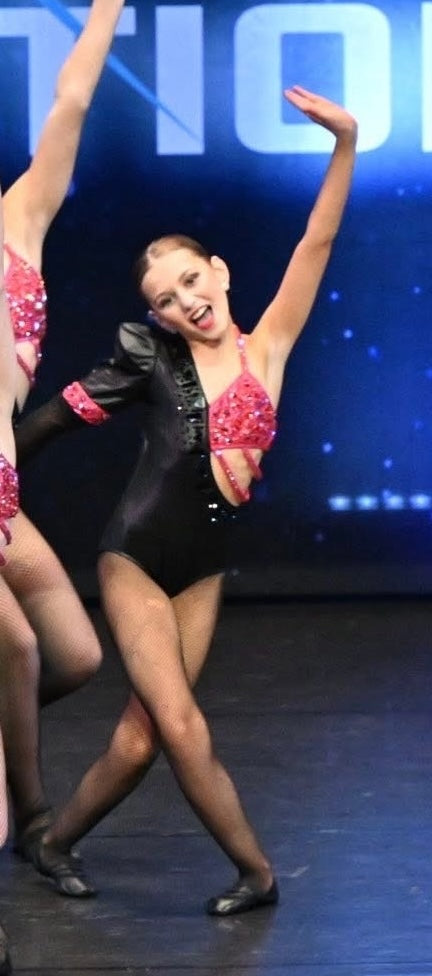Mia performing with her competition team on stage